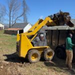 Barney loading junk in to trailer with skidsteer